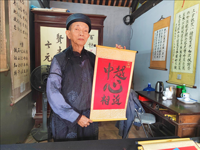 越南首都河內(nèi)文廟內(nèi)，阮明珠展示“中越心相近”書法作品。
