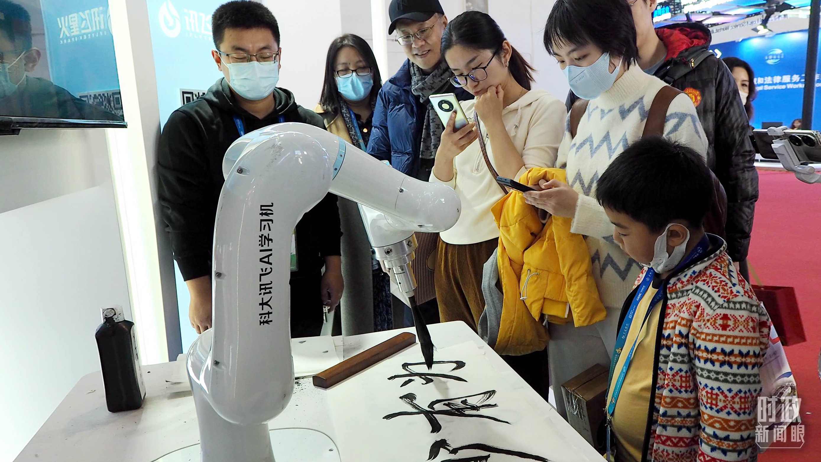 △觀眾在首屆鏈博會上體驗AI書法機器人。