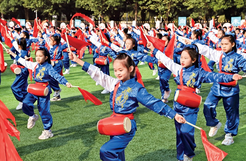 為助推民族地區(qū)基礎(chǔ)教育事業(yè)發(fā)展，廣西重新核定各地中小學(xué)教職工編制，依托全區(qū)編制“周轉(zhuǎn)池”核增事業(yè)編制給各地中小學(xué)，在全面達(dá)到國(guó)家標(biāo)準(zhǔn)的基礎(chǔ)上，進(jìn)一步統(tǒng)籌優(yōu)化和動(dòng)態(tài)調(diào)整各區(qū)域、學(xué)校、學(xué)段間編制資源。圖為2023年11月29日，南寧市濱湖路小學(xué)舉行主題為“逐夢(mèng)新時(shí)代 健體向未來(lái)”的體育文化節(jié)，孩子們正在跳腰鼓舞。 新華社記者 周華/攝