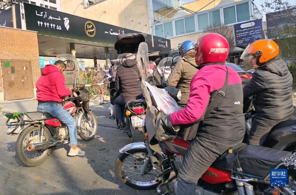 12月18日，摩托車在伊朗首都德黑蘭的一家加油站外等待加油。新華社記者 沙達(dá)提 攝