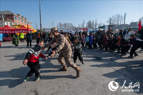 12月22日，在積石山縣大河家鎮(zhèn)大河村安置點，陸軍76集團(tuán)軍某旅官兵通過游戲方式，對小朋友進(jìn)行災(zāi)后心理疏導(dǎo)。人民網(wǎng)記者 翁奇羽攝