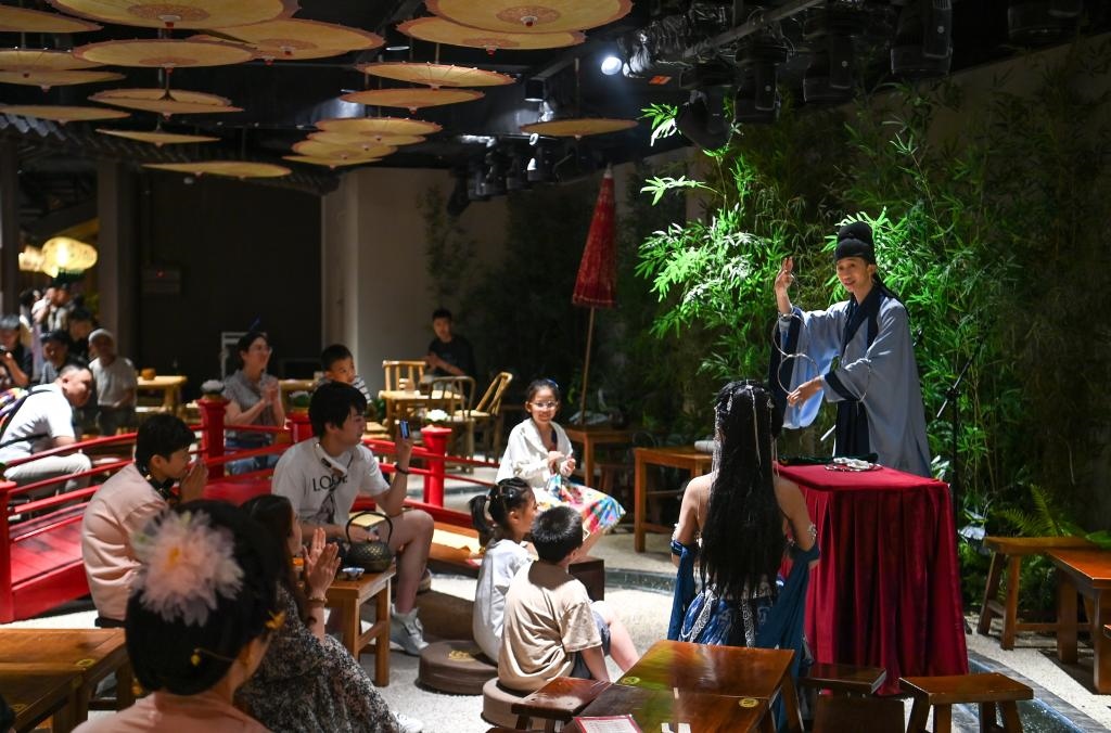 游客在長安十二時辰主題街區(qū)觀看唐風(fēng)演藝《大唐曲藝》。新華社記者鄒競一 攝