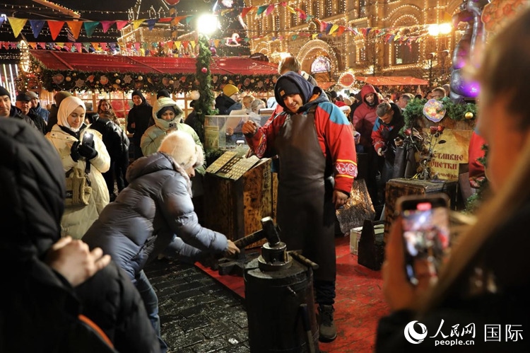 游客在新年集市上體驗(yàn)制作紀(jì)念幣。人民網(wǎng)記者 隋鑫攝