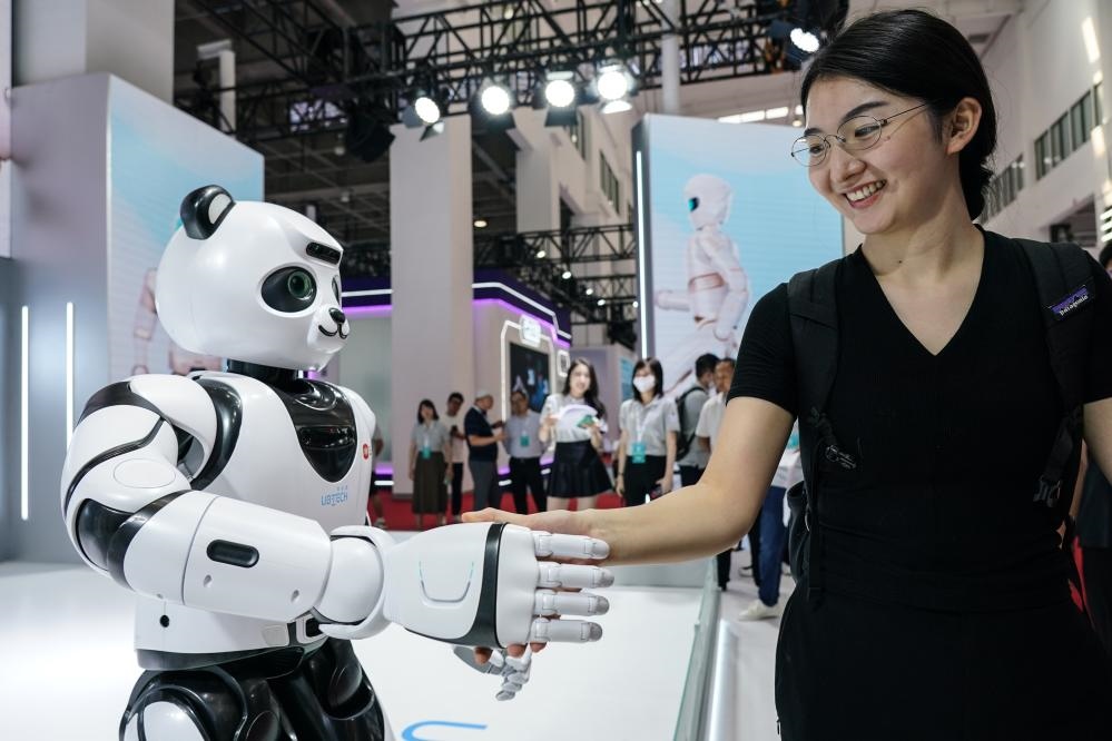 2023年8月16日，一名女士在北京舉辦的2023世界機(jī)器人大會(huì)現(xiàn)場與智能機(jī)器人握手。新華社記者彭子洋攝