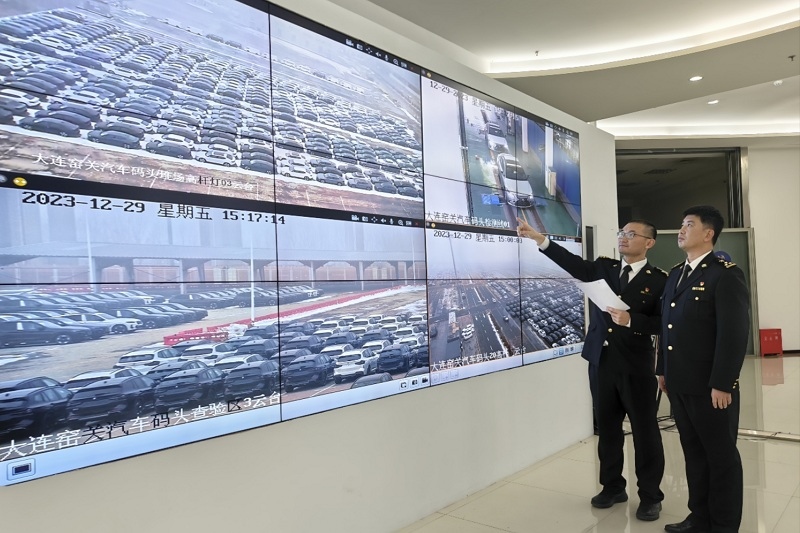 海關(guān)關(guān)員視頻巡查出口汽車場地。李進攝