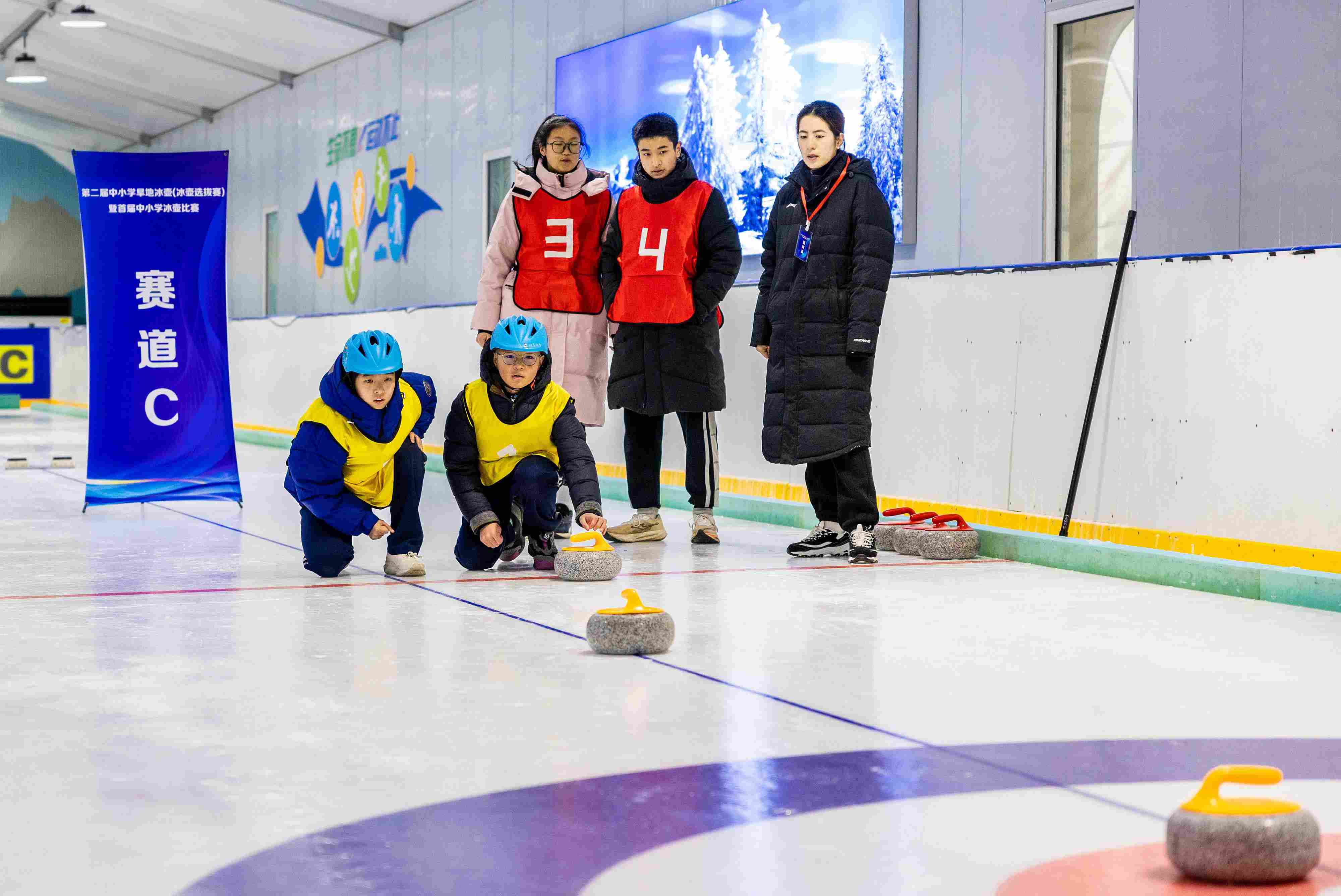 2023年12月10日，參賽選手在呼和浩特首屆中小學(xué)冰壺比賽中投擲冰壺。