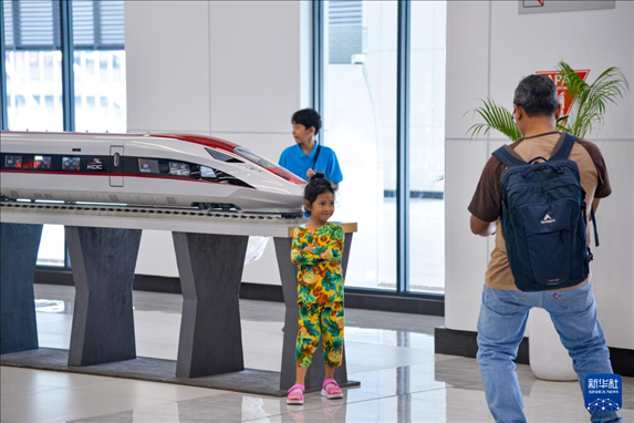 1月24日，在印度尼西亞雅加達(dá)哈利姆站候車大廳，一名小朋友和雅萬高鐵高速動(dòng)車組模型合影。新華社記者 徐欽 攝