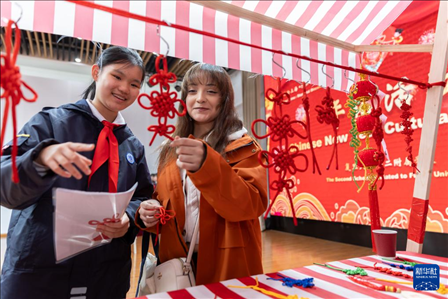 1月28日，復(fù)旦大學(xué)第二附屬學(xué)校學(xué)生（左）為美國(guó)馬斯卡廷中學(xué)學(xué)生（右）介紹中國(guó)結(jié)。 新華社記者 王翔 攝