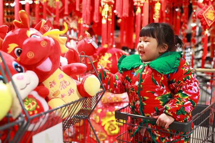 1月23日，在貴州省黔東南苗族侗族自治州岑鞏縣一家超市，小朋友在家人的帶領(lǐng)下選購龍年毛絨玩具。新華社發(fā)（唐鵬攝）