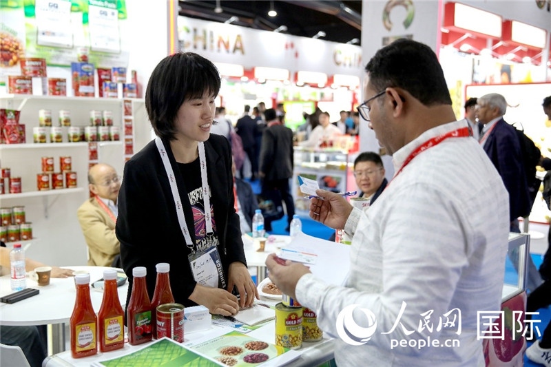 圖為中國參展企業(yè)代表與采購商交流。人民網(wǎng) 塔里克·易卜拉欣攝
