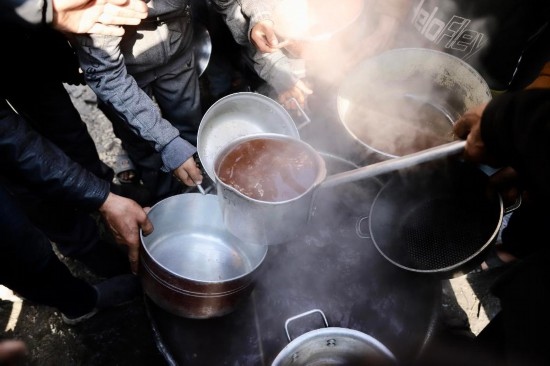  2月27日，在加沙地帶北部的杰巴利耶難民營(yíng)，人們領(lǐng)取食物。新華社發(fā)（穆罕默德·阿里攝）