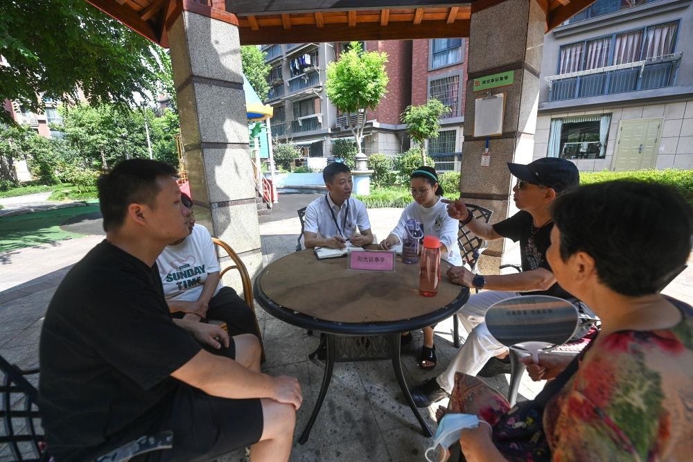 △2023年7月21日，在位于浙江杭州臨安區(qū)錦南街道水岸陽光小區(qū)的陽光議事廳，街道干部在聽取居民們反映的問題及意見。