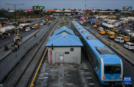 3月4日，在尼日利亞拉各斯，一列輕軌藍(lán)線列車行駛至公路交通擁堵路段附近。新華社記者 韓旭 攝
