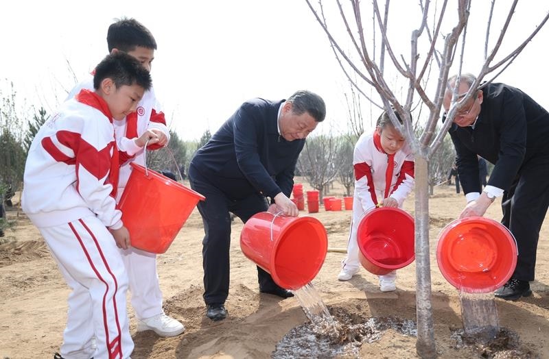 2024年4月3日，習(xí)近平總書記同少先隊(duì)員一起給剛栽下的樹苗澆水。