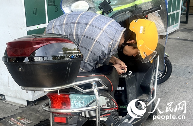 杭州一名外賣騎手正在更換共享電池。人民網(wǎng)記者 張麗瑋攝