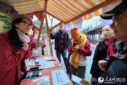 1月6日，“2024成都蒲江柑甜采摘節(jié)”上，記者見到了小萌（左一）和許多年輕人忙著做訪客接待、現(xiàn)場布置、票務核對、采摘服務等工作。人民網(wǎng)記者朱虹攝