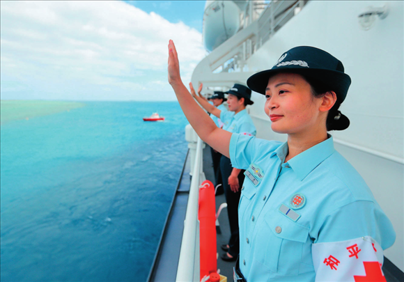 中國(guó)海軍“和平方舟”號(hào)醫(yī)院船結(jié)束訪問(wèn)湯加時(shí)，任務(wù)官兵中的文職人員向歡送人群揮手告別（2023年8月4日攝）。徐巍攝/本刊
