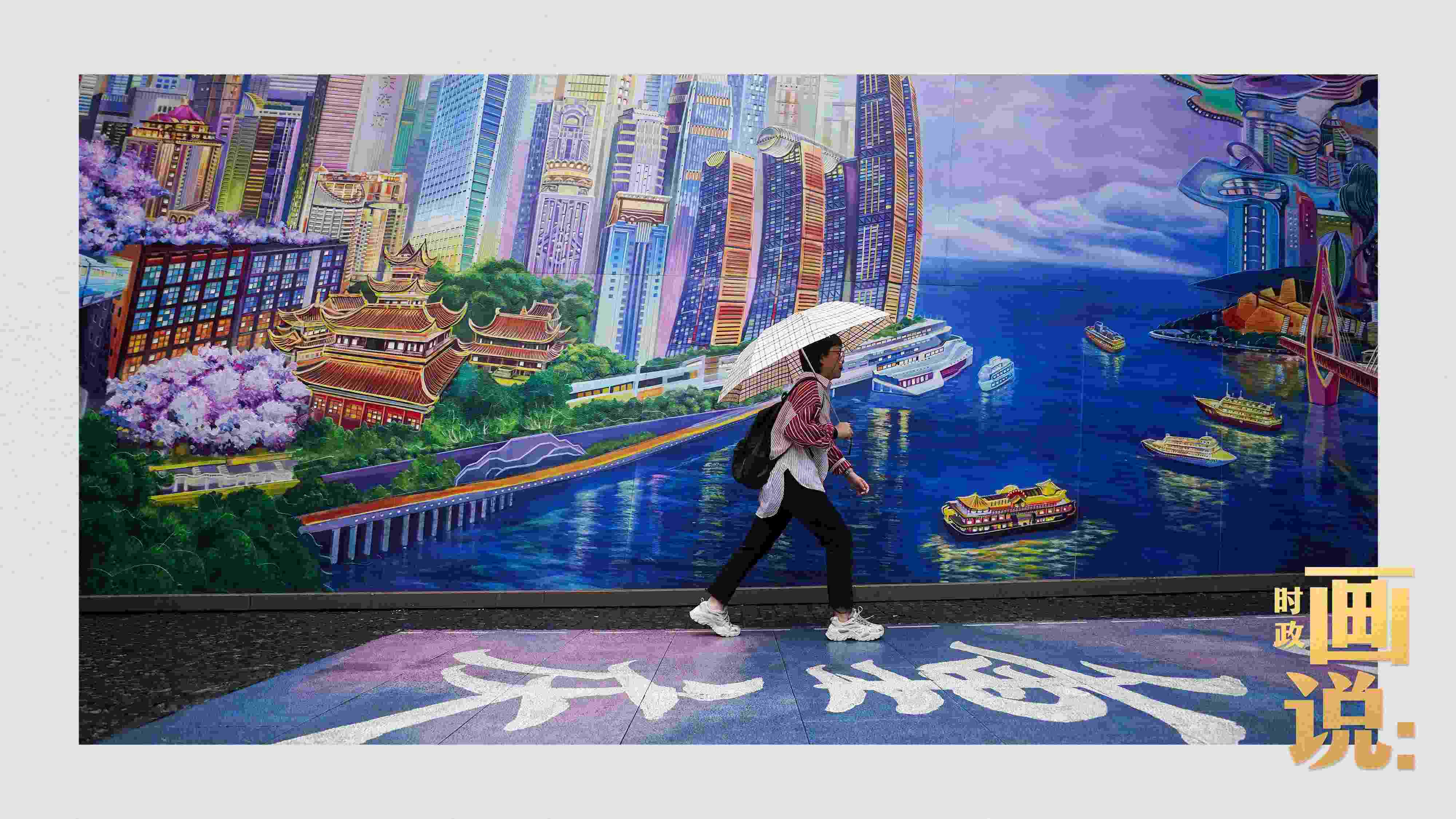 △小雨中，行人走過(guò)“重慶畫(huà)卷”主題壁畫(huà)。