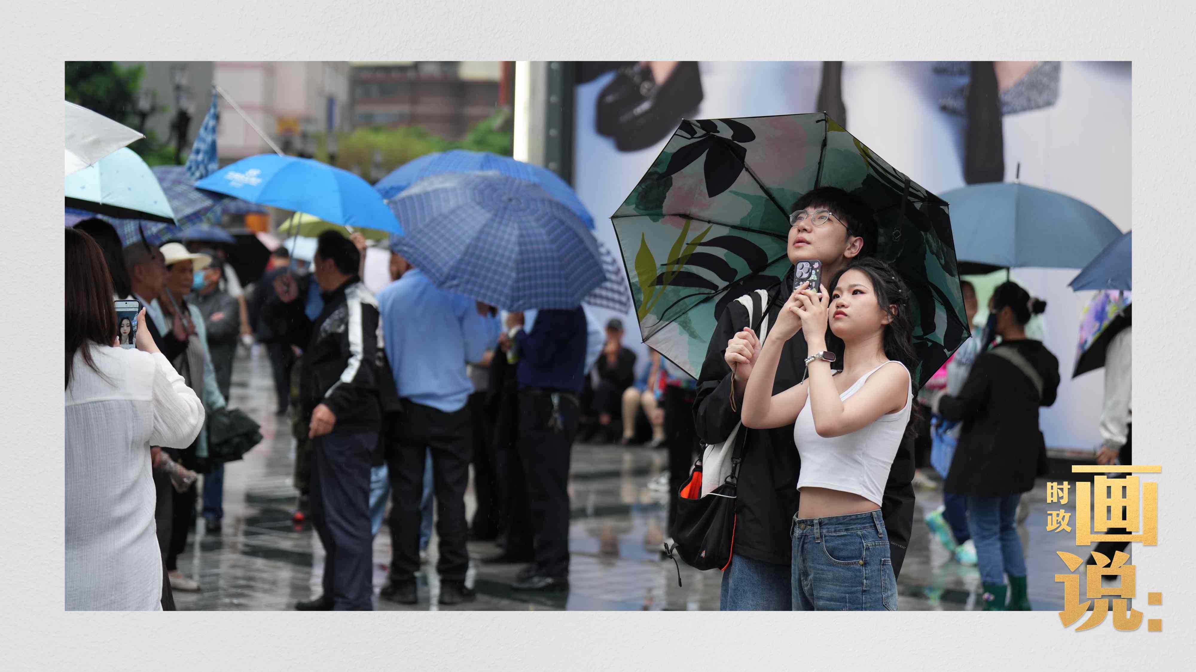 △細(xì)雨中的解放碑步行街，騎在父親肩膀的小女孩好奇張望。