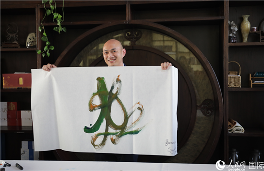 老撾駐華大使館三秘明君參加《五百筆·瀾湄合作》集體藝術(shù)創(chuàng)作。人民網(wǎng)王婧攝。