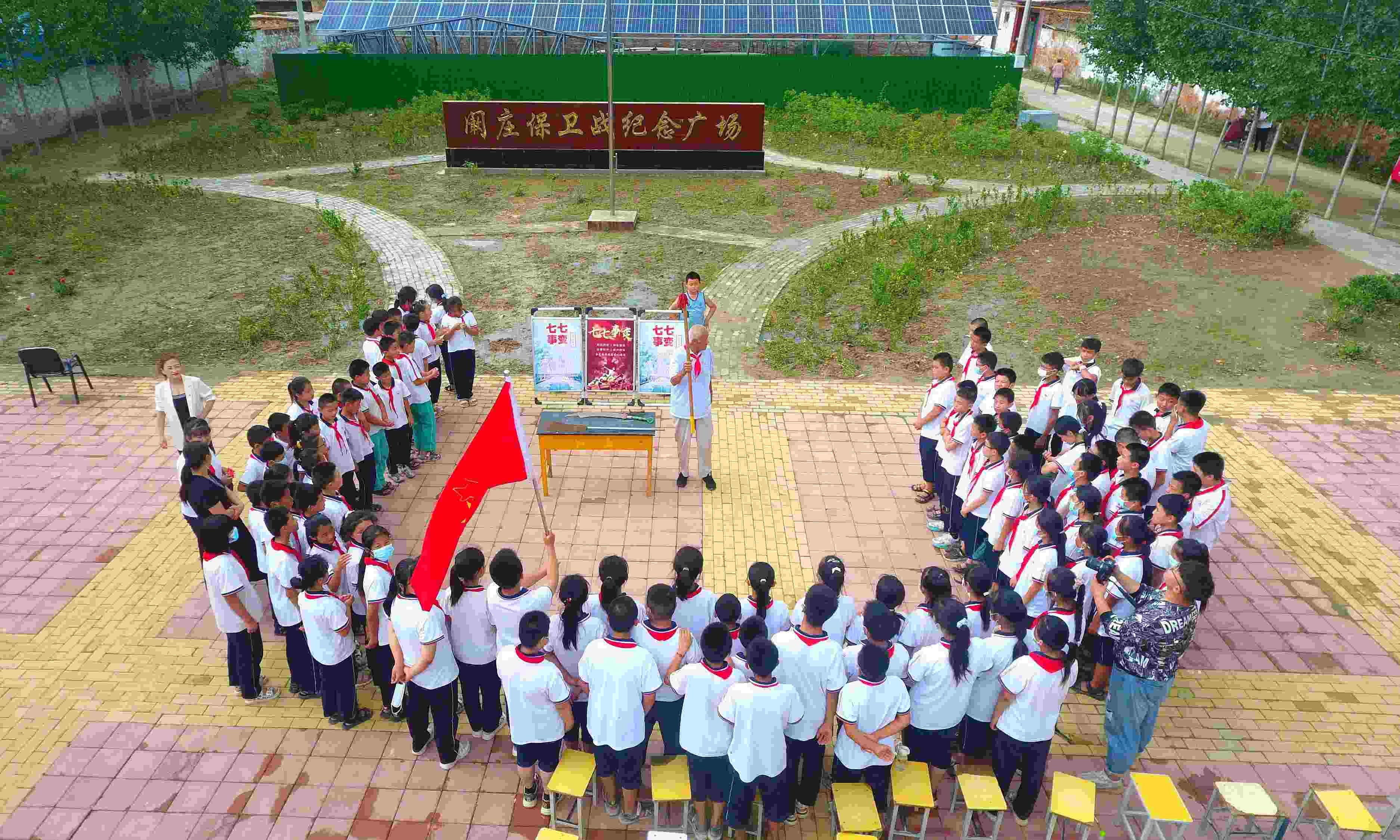 2022年7月6日，山東省聊城市，在茌平區(qū)菜屯鎮(zhèn)闞莊村的闞莊保衛(wèi)戰(zhàn)紀(jì)念廣場，闞莊保衛(wèi)戰(zhàn)親歷者王光木老人為小學(xué)生們講述抗戰(zhàn)故事，展示大刀、長矛。