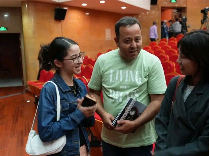 阿爾及利亞市民拉納·艾薩尼和她父親現(xiàn)場聆聽中阿交響樂演出 。蘇州交響樂團(tuán)供圖