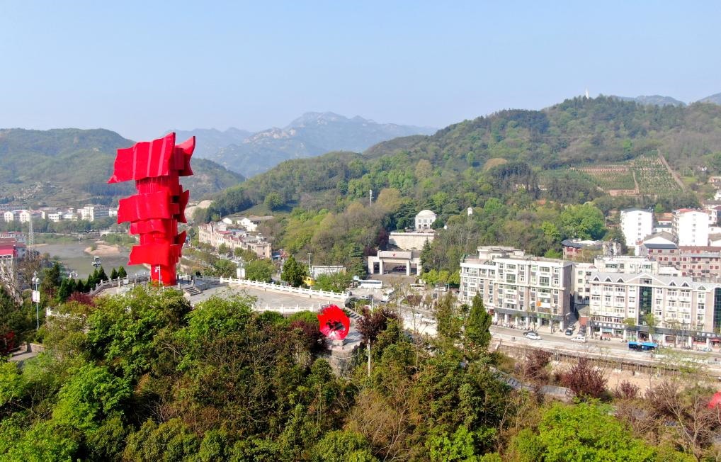 這是2021年4月9日拍攝的鄂豫皖蘇區(qū)首府革命博物館附近的英雄山上的“紅旗飄飄”主題雕塑（無人機照片）。新華社發(fā)