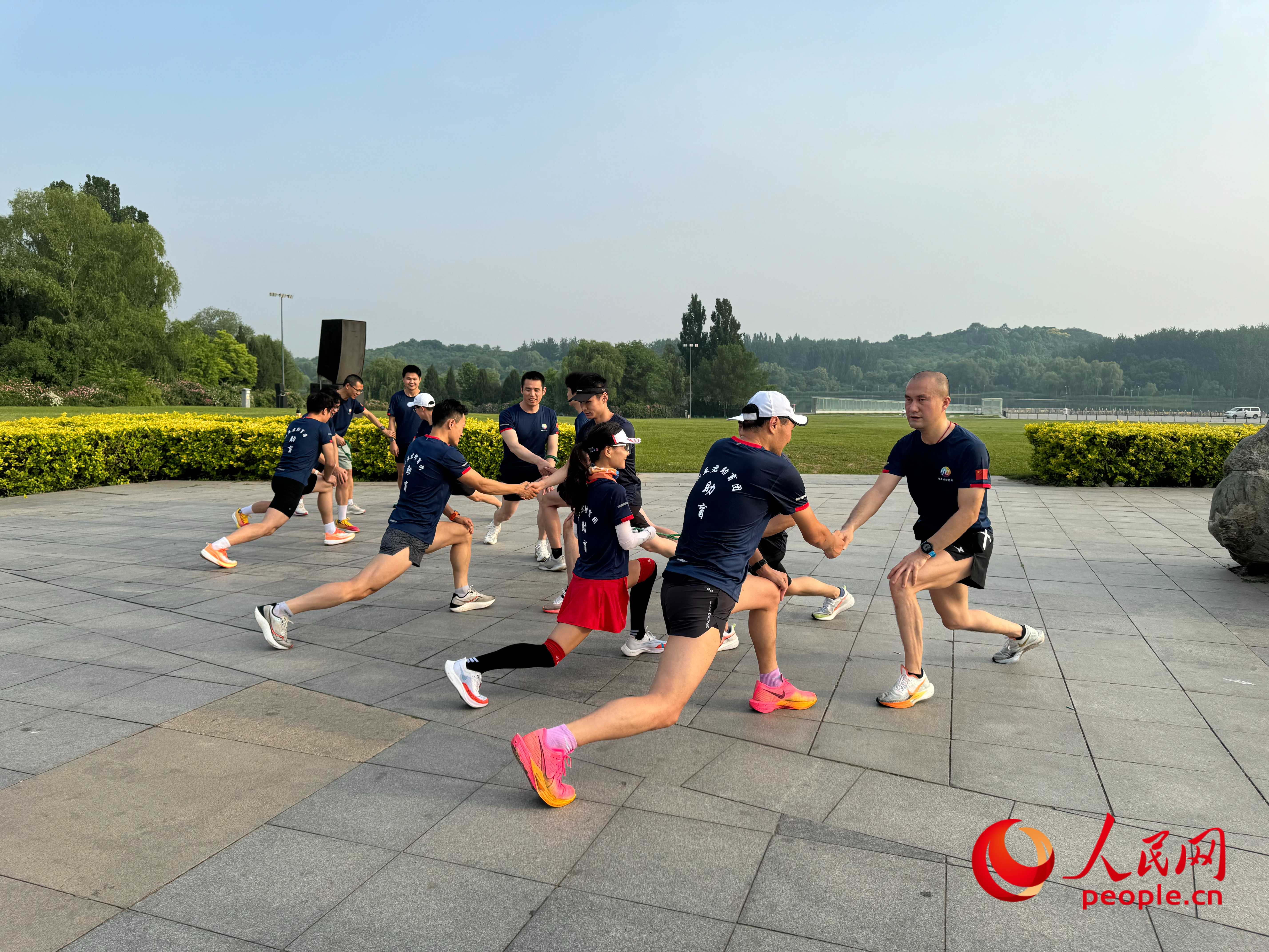 盲人和志愿者做跑步前準(zhǔn)備。人民網(wǎng) 周靜圓攝