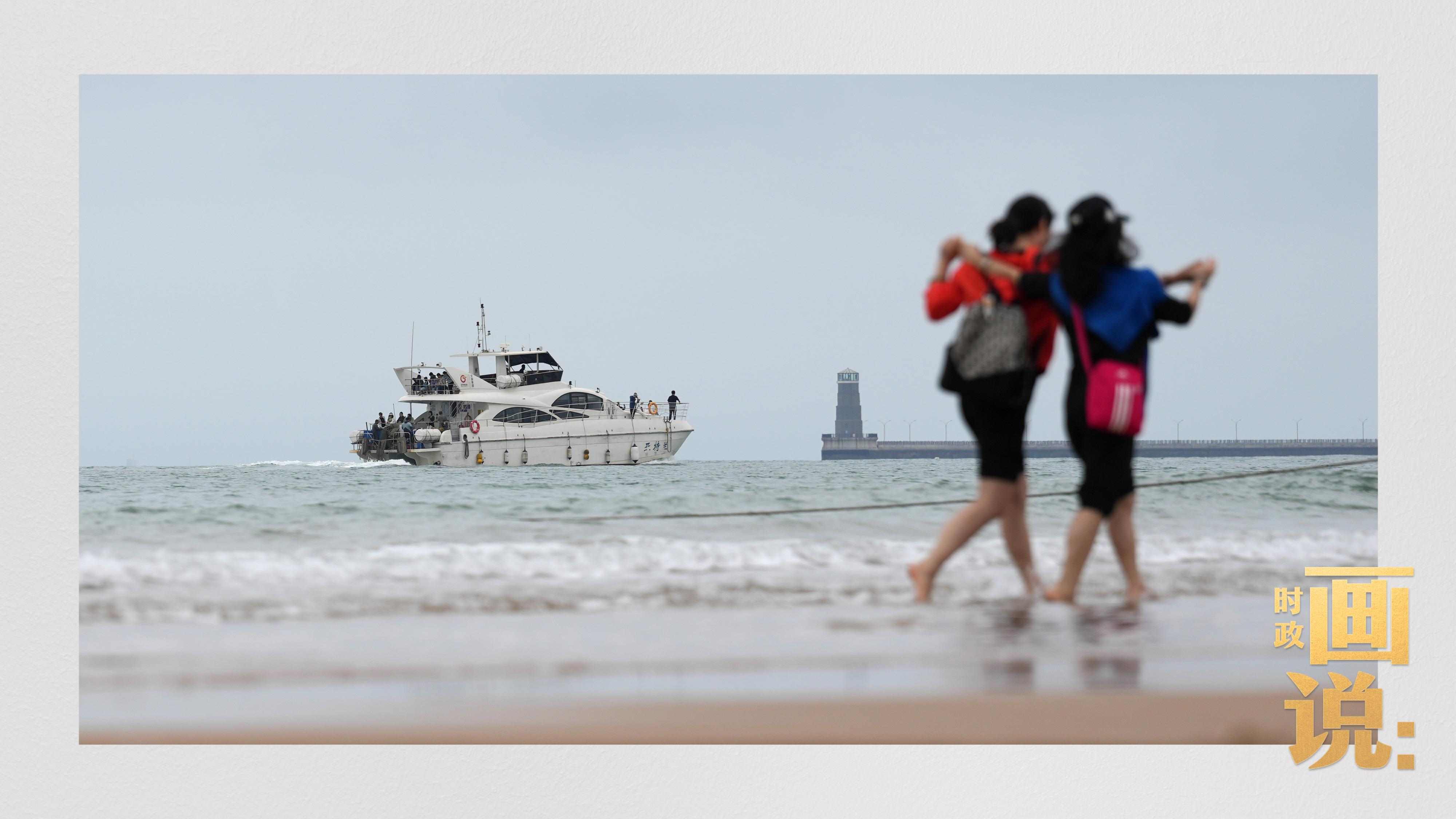 △日照陽光海岸綠道上的萬平口景區(qū)，一對游客在海浪中翩然起舞。