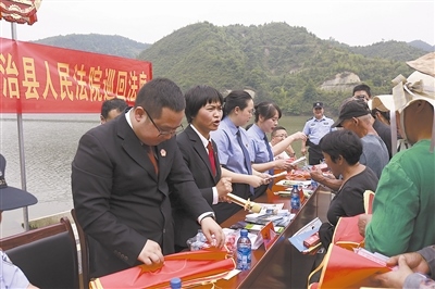 法院干警及相關(guān)部門工作人員對群眾進(jìn)行生態(tài)環(huán)境保護(hù)普法教育。