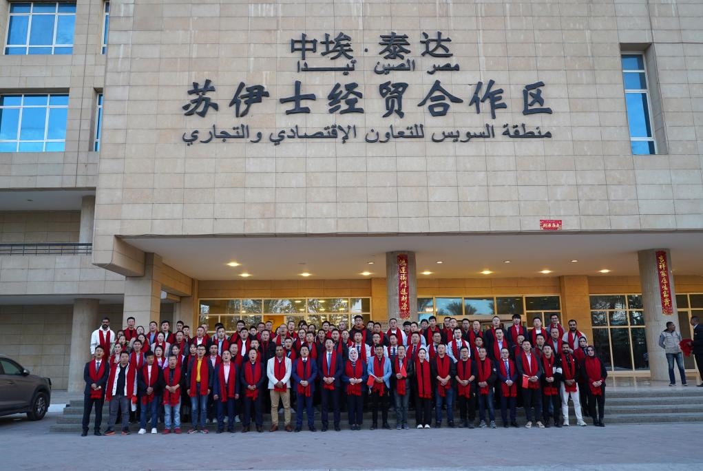 2024年2月11日，在位于埃及蘇伊士省的中?！ぬ┻_(dá)蘇伊士經(jīng)貿(mào)合作區(qū)，中埃員工在合作區(qū)辦公大樓前合影拜年。新華社發(fā)（泰達(dá)合作區(qū)供圖）