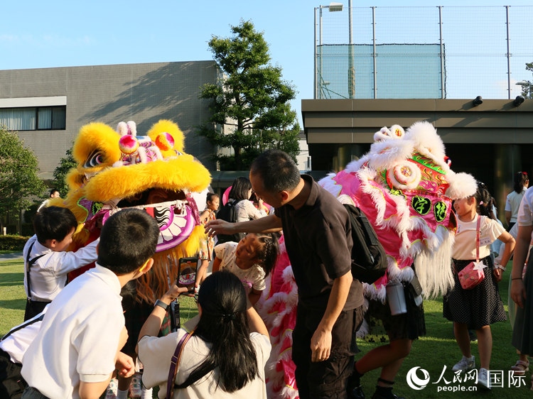 孩子們好奇地圍觀舞獅。人民網(wǎng) 許可攝