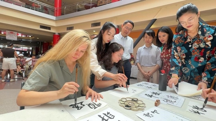 羅馬尼亞友人在活動(dòng)現(xiàn)場(chǎng)學(xué)寫漢字。中國駐羅馬尼亞大使館領(lǐng)僑處供圖