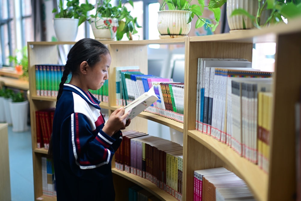 6月18日，果洛西寧民族中學學生尼東拉毛在圖書室看書。