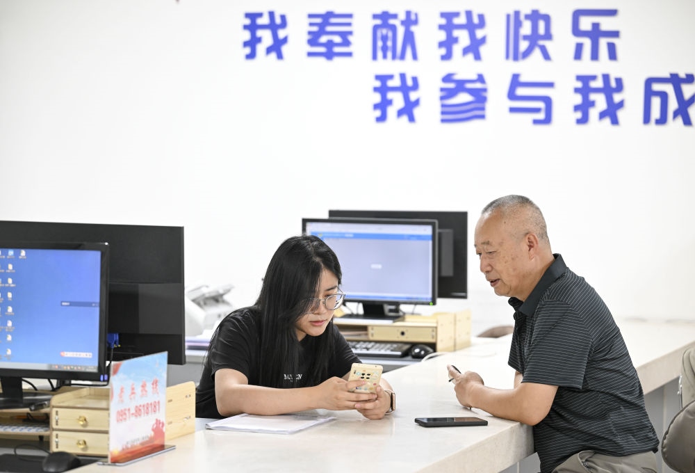 6月20日，在長城花園社區(qū)黨群服務中心，工作人員幫助居民辦理業(yè)務。