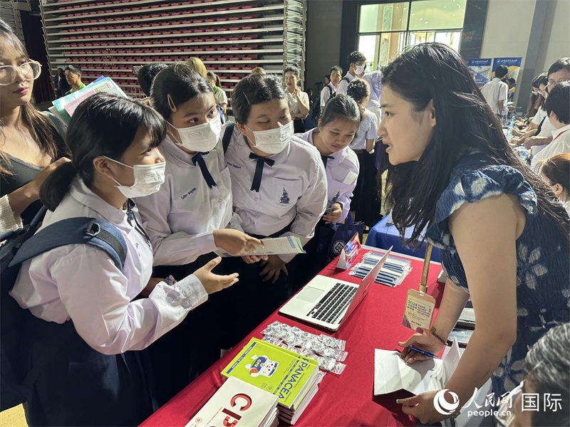 來自泰國的學生、家長在教育展臺前咨詢。人民網(wǎng)記者 簡承淵攝
