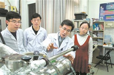 2017年10月，清華大學(xué)低維量子物理國(guó)家重點(diǎn)實(shí)驗(yàn)室，薛其坤（左三）與學(xué)生討論實(shí)驗(yàn)工作。 苑潔攝