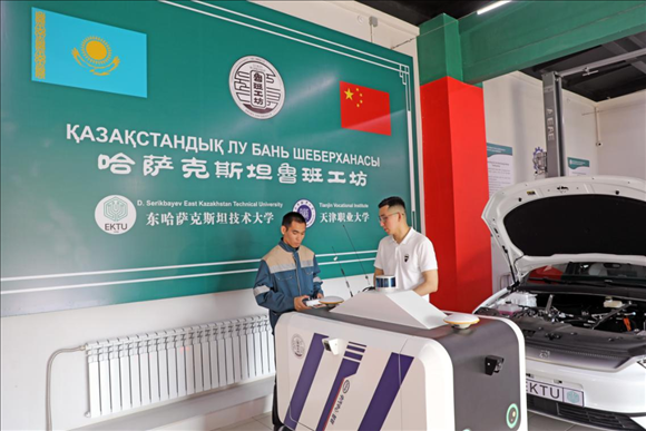 在哈薩克斯坦魯班工坊汽車維修技術實訓區(qū)，兩名技術員正在操作調試由中方提供的智能機器人車。哈薩克斯坦魯班工坊位于東哈薩克斯坦州首府厄斯克門，該項目由天津職業(yè)大學與東哈薩克斯坦技術大學共同承建，于2023年12月9日開始試運行。本報記者 趙益普 攝