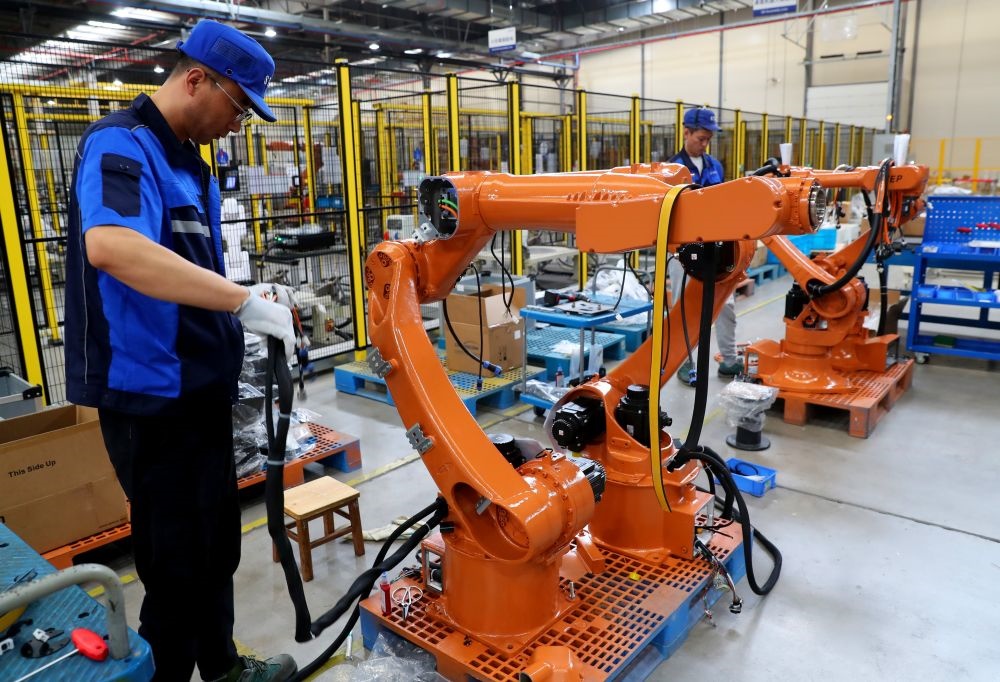 工作人員在上海新時(shí)達(dá)機(jī)器人有限公司位于嘉定的智能工廠內(nèi)忙碌（2024年5月23日攝）。新華社記者 龔兵 攝