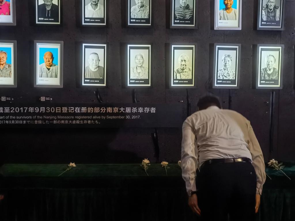7月18日，人們向離世的南京大屠殺幸存者獻(xiàn)花、鞠躬。新華社記者邱冰清 攝