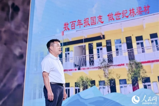 張玉滾分享用一根扁擔(dān)送孩子們走出大山的故事。人民網(wǎng)攝