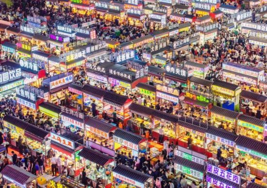2024年4月21日，人們?cè)诤颖笔≌h小商品夜市品嘗美食（無人機(jī)照片）。新華社發(fā)（武志偉 攝）