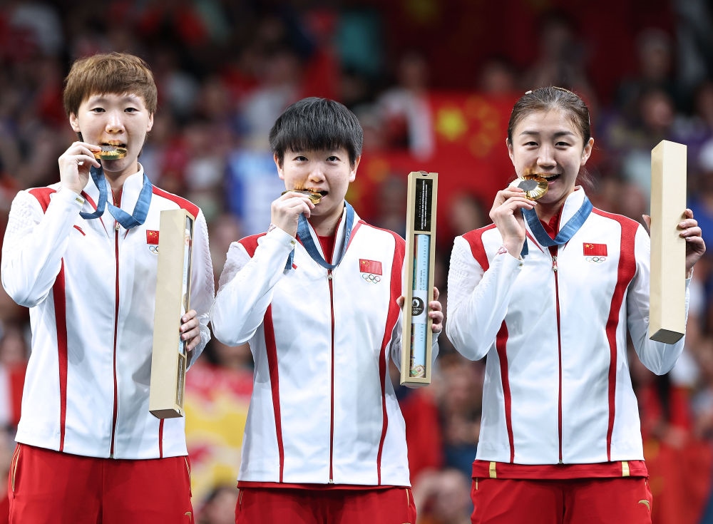 冠軍中國隊(duì)選手王曼昱、孫穎莎、陳夢(mèng)（從左至右）在巴黎奧運(yùn)會(huì)乒乓球女子團(tuán)體頒獎(jiǎng)儀式上（2024年8月10日攝）。新華社記者 王東震 攝