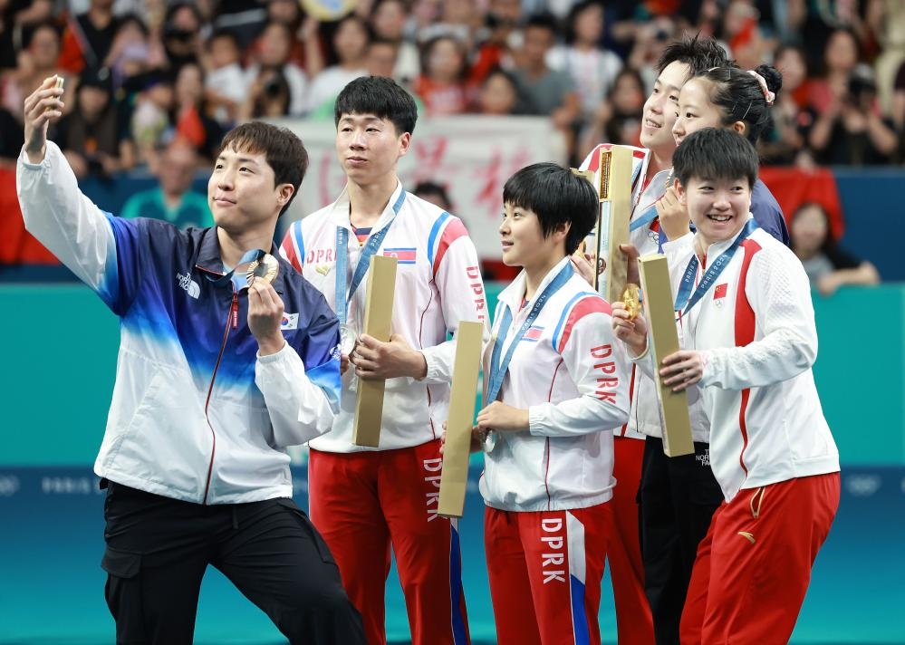 冠軍中國組合王楚欽（右三）/孫穎莎（右一）、亞軍朝鮮組合李正植（左二）/金琴英（左三）、季軍韓國組合林鐘勛（左一）/申裕斌在巴黎奧運(yùn)會(huì)乒乓球混雙頒獎(jiǎng)儀式上合影（2024年7月30日攝）。新華社記者 劉續(xù) 攝
