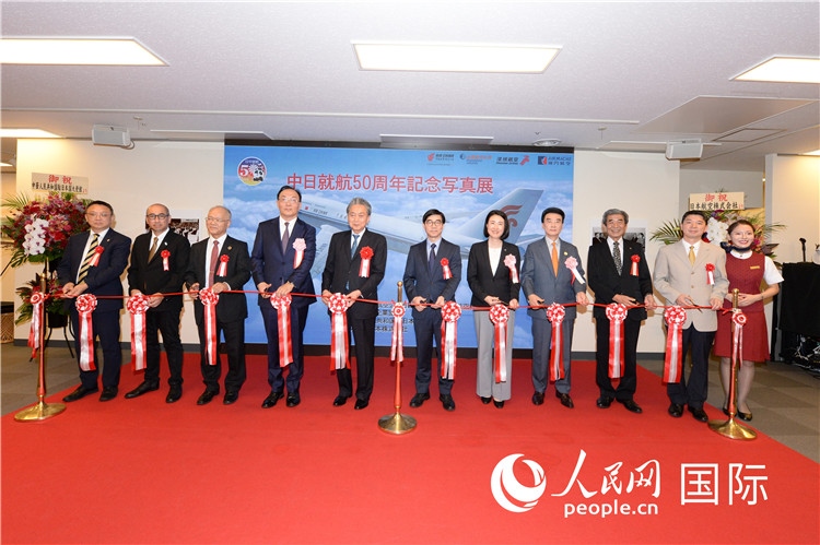 與會嘉賓共同為中日通航50周年紀念圖片展開幕剪彩。馮學(xué)敏攝