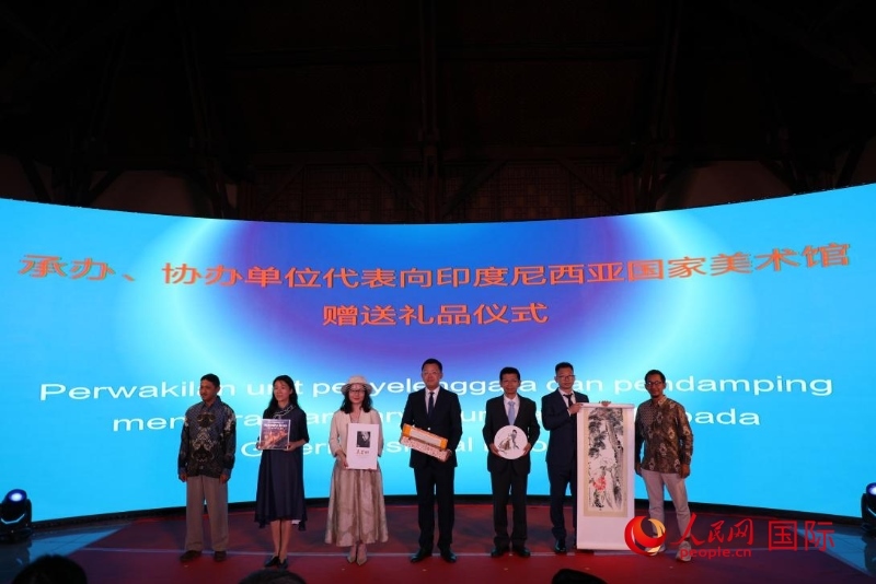 在展覽開幕式現(xiàn)場，本次展覽的承辦、協(xié)辦單位代表向印尼國家美術館贈送禮品。人民網記者 曹師韻攝
