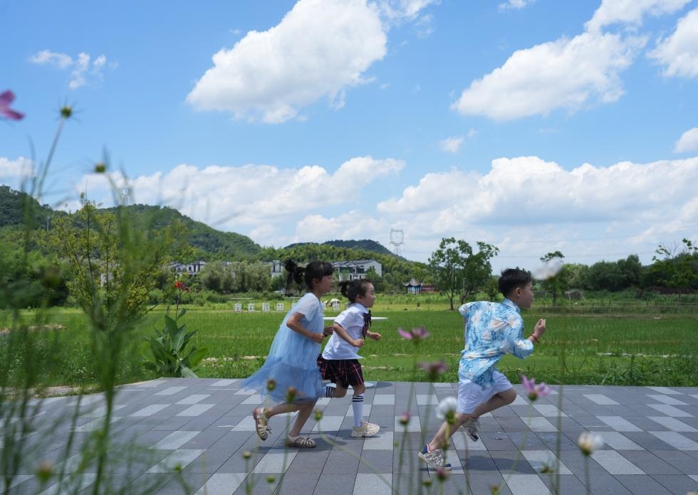 兒童在余姚市梁弄鎮(zhèn)的田野間奔跑（7月3日攝）。新華社記者翁忻旸 攝