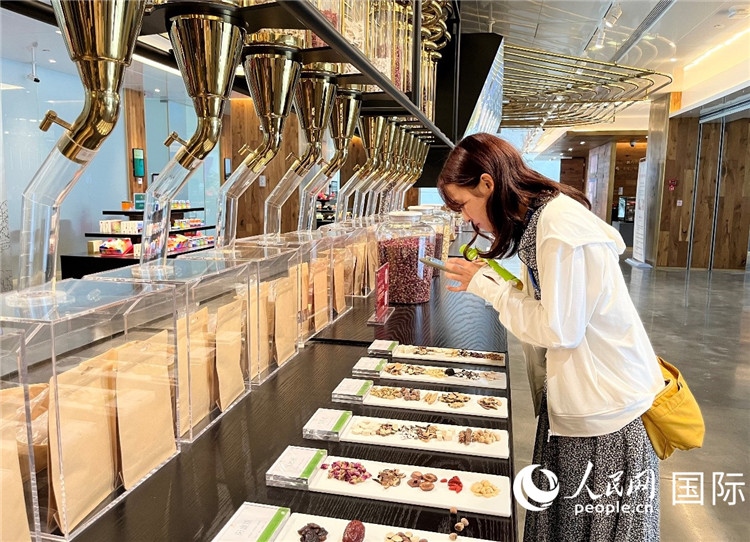 4. 代表團(tuán)團(tuán)員對(duì)新中式茶飲的食材充滿興趣。（人民網(wǎng)記者陳思 攝）