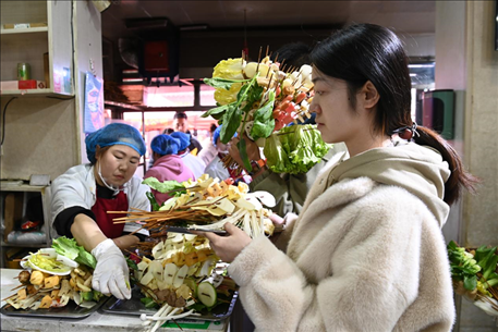 游客挑選好麻辣燙菜品后排隊(duì)等待加工。新華社記者 范培珅 攝