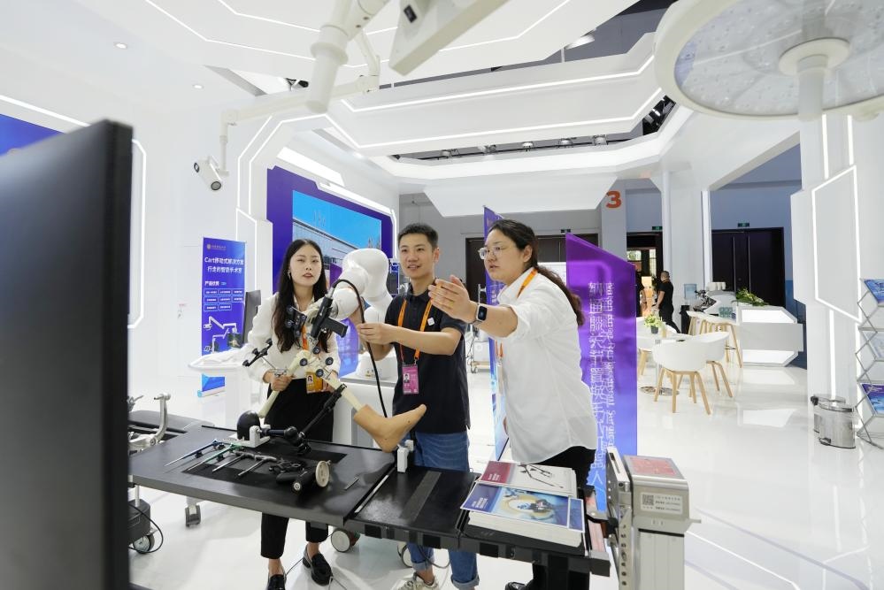 9月11日，一位媒體記者（中）在2024年服貿(mào)會(huì)國家會(huì)議中心會(huì)場(chǎng)體驗(yàn)北京納通科技集團(tuán)有限公司的膝關(guān)節(jié)置換手術(shù)機(jī)器人。新華社記者鞠煥宗 攝